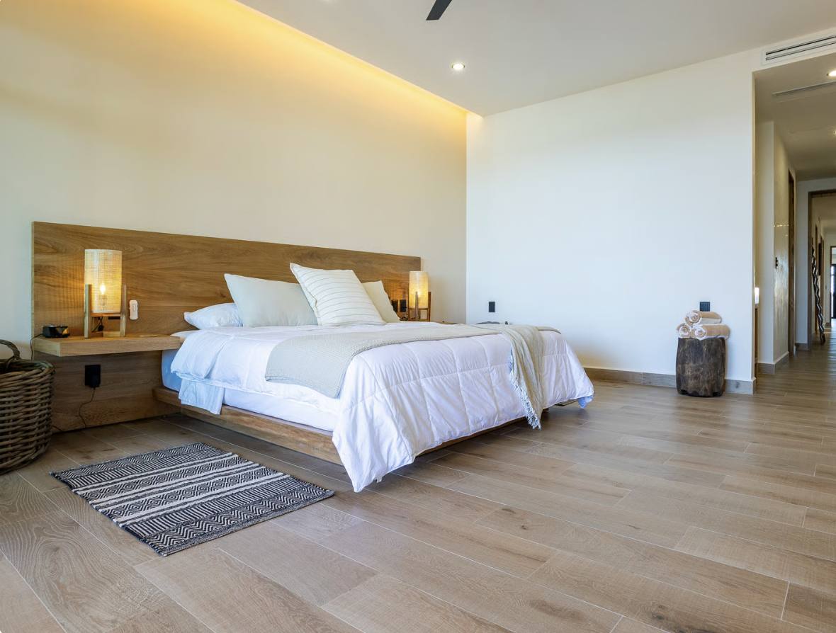 A bedroom with a wooden headboard and warm light