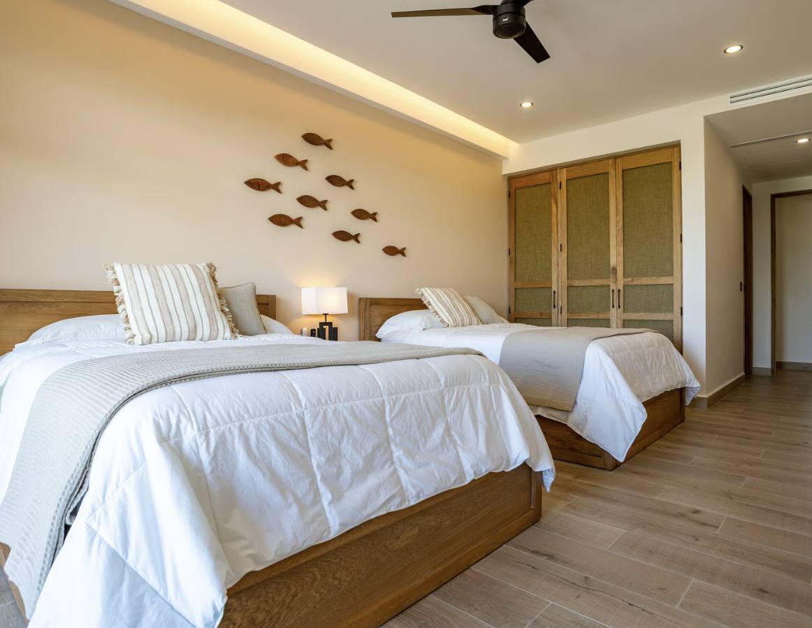 A twin bedroom with wooden fish on the wall