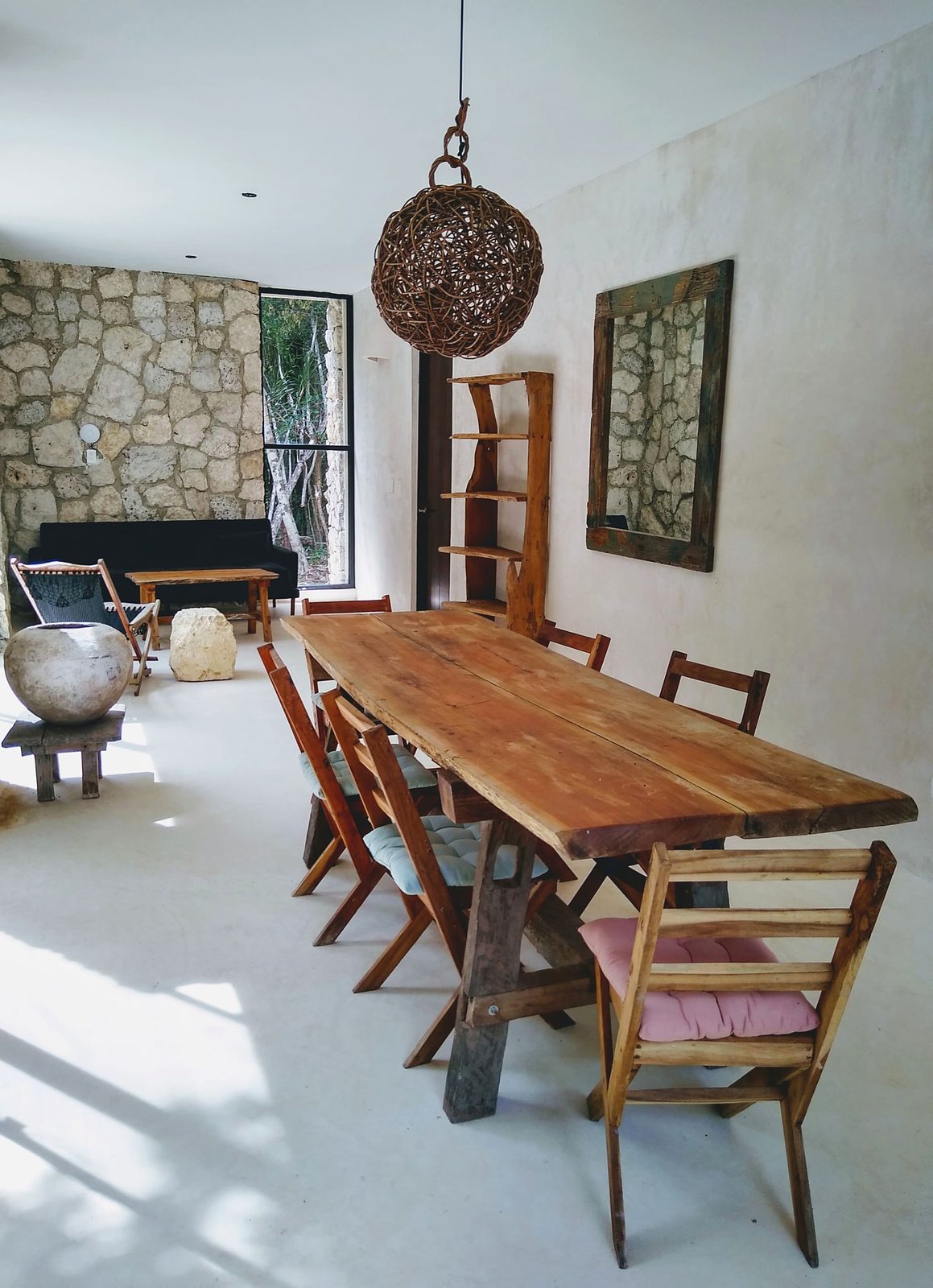 A long wooden dining table in the stone-walled common room