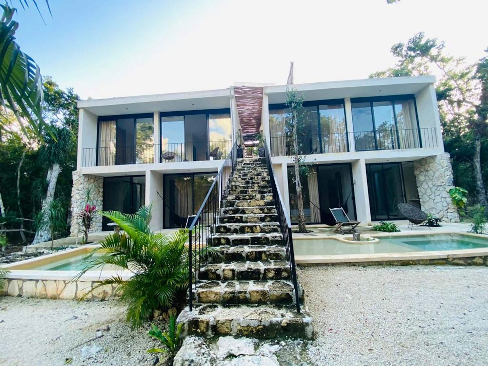 The two-storey suite building with its stone stairway and plunge pools