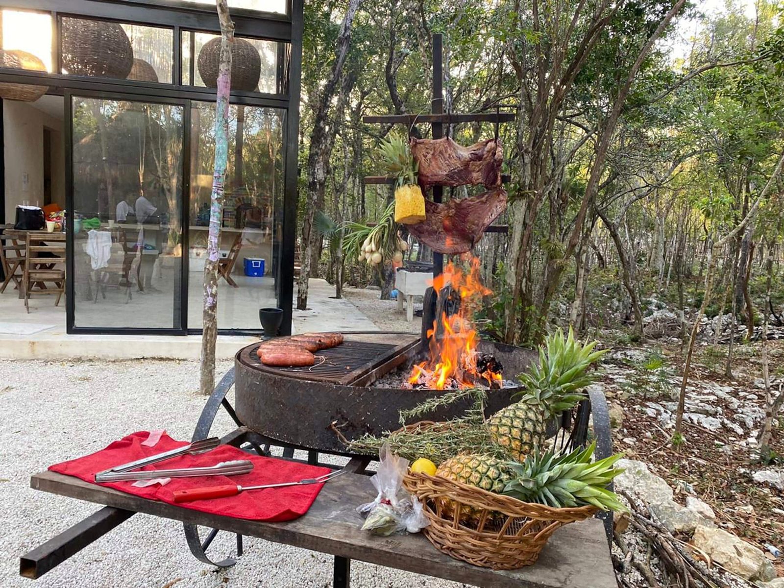 Open-fire grill with fruit and meat set up outdoors