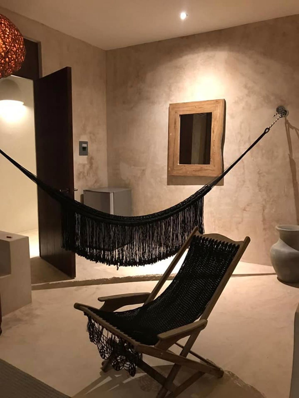A suite corner with a woven hammock and a lounge chair