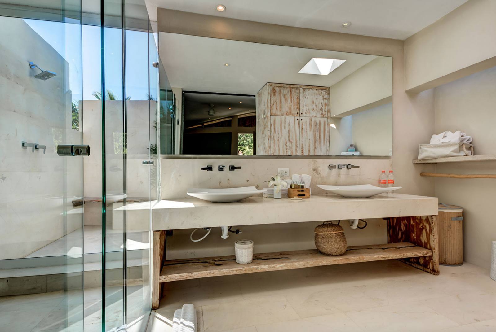 A bathroom with a glass shower and a double vanity
