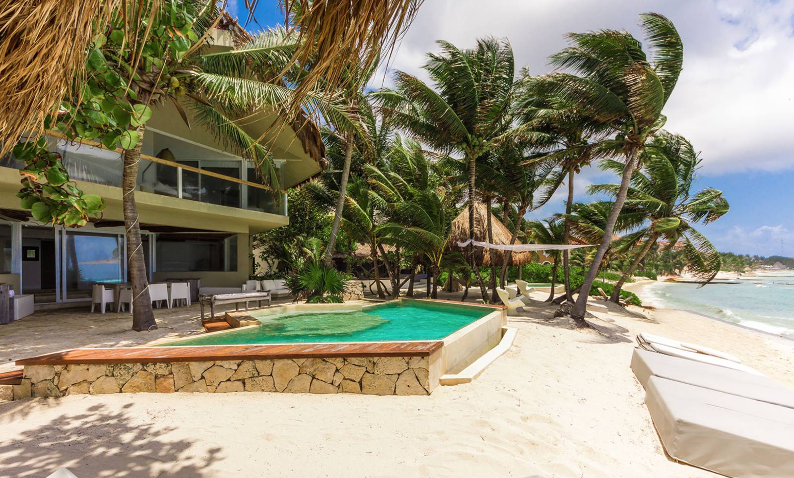 The pool on the sand among the palms