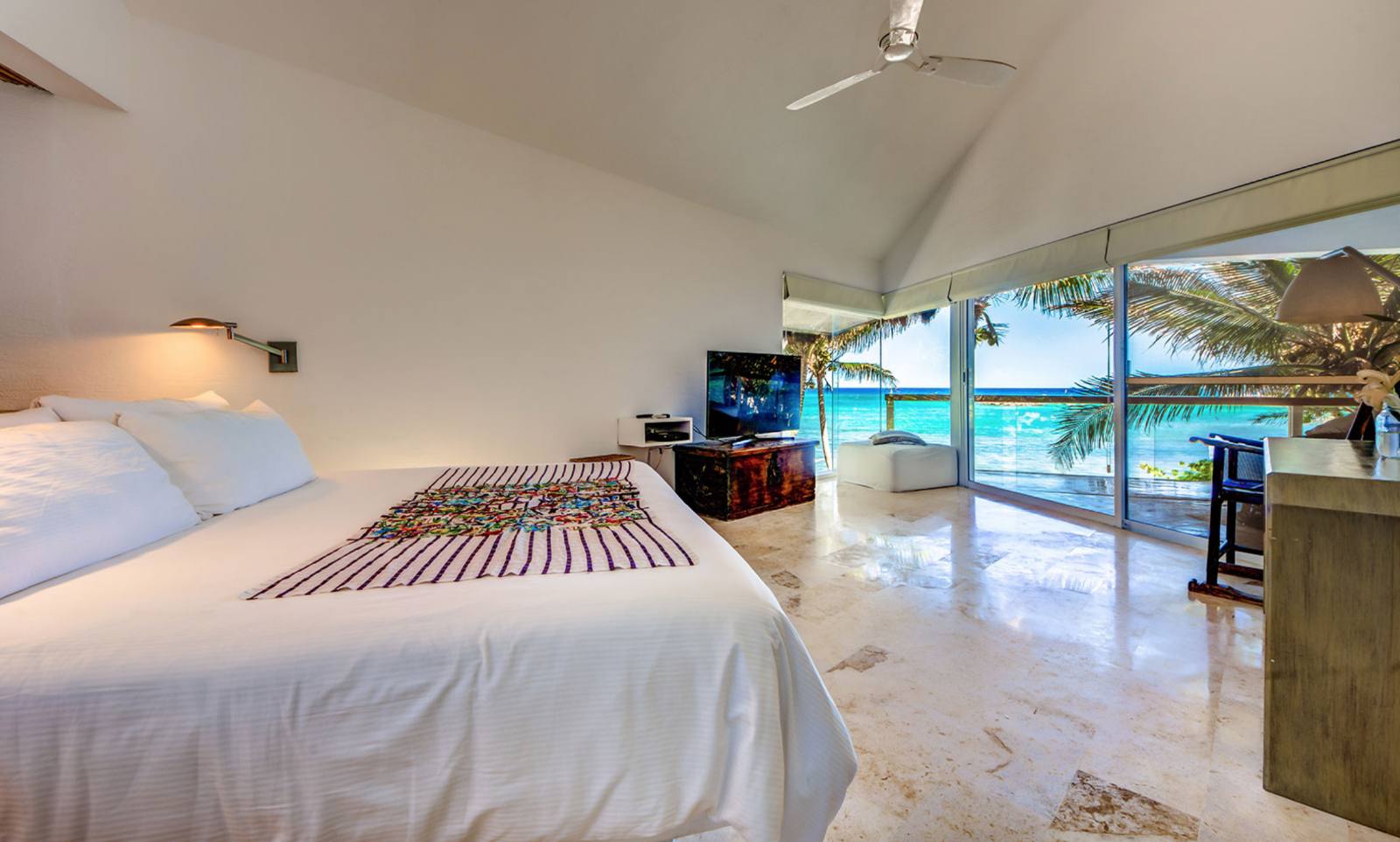 A bedroom with sea views and an embroidered runner