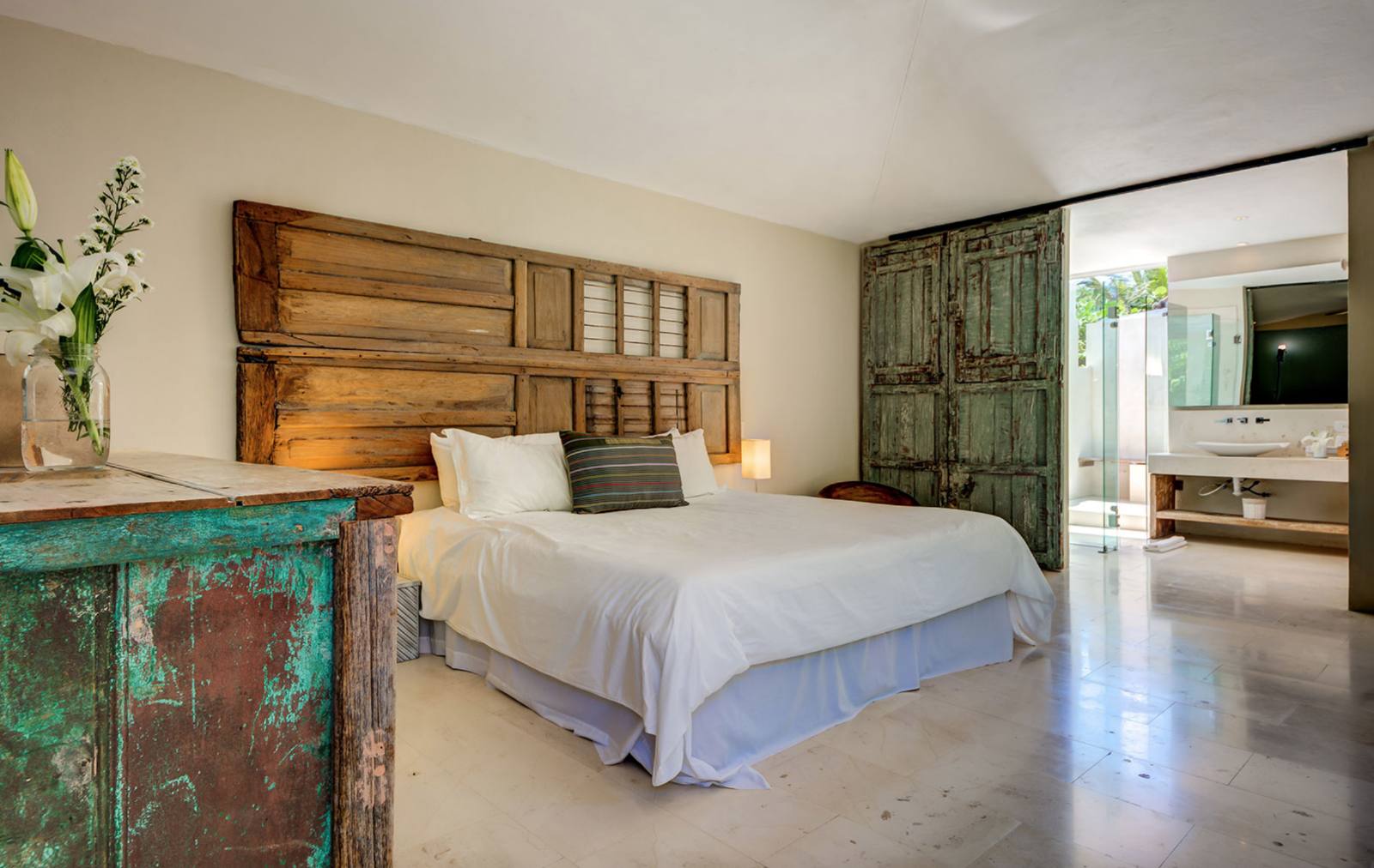 A bedroom with a vintage green armoire