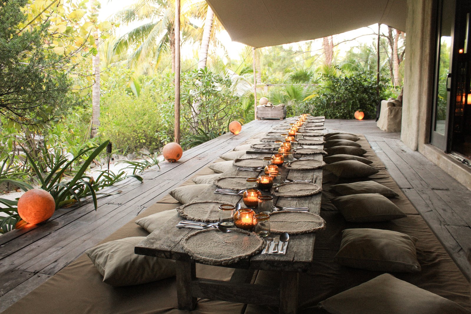 A long dining table on the terrace, set with candles