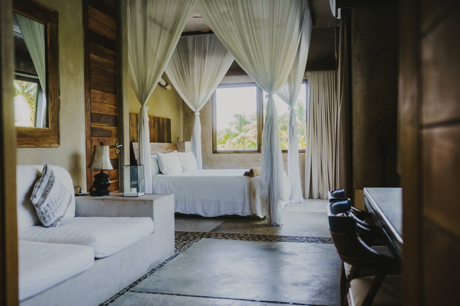 The master suite with a king bed and linen curtains