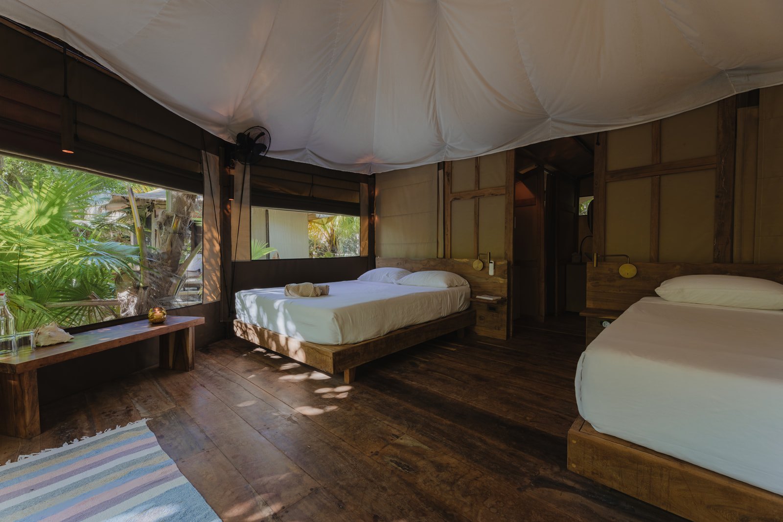 Inside a safari tent: two beds on a wooden floor