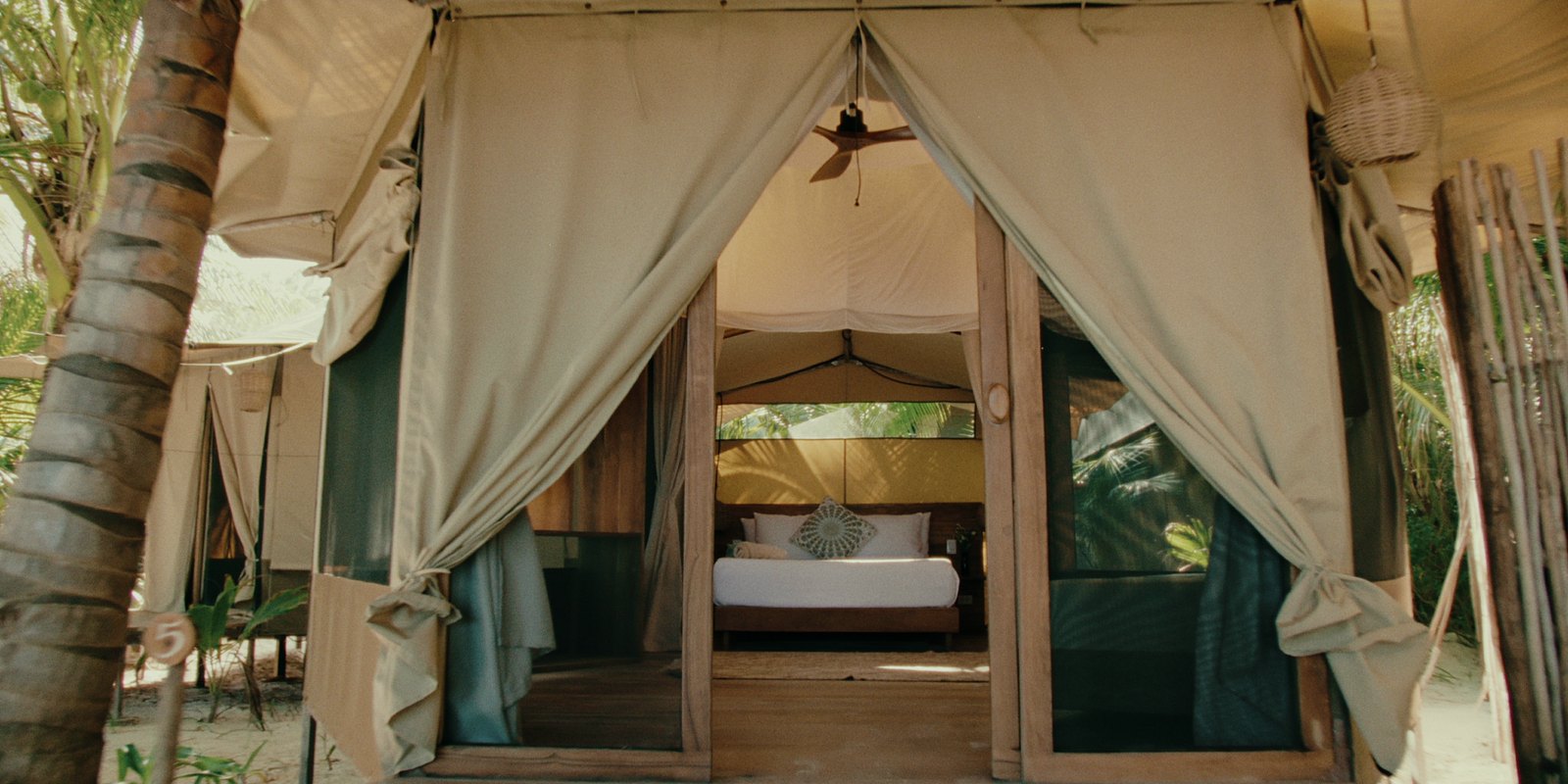 A safari tent with a queen bed and a pull-out bed