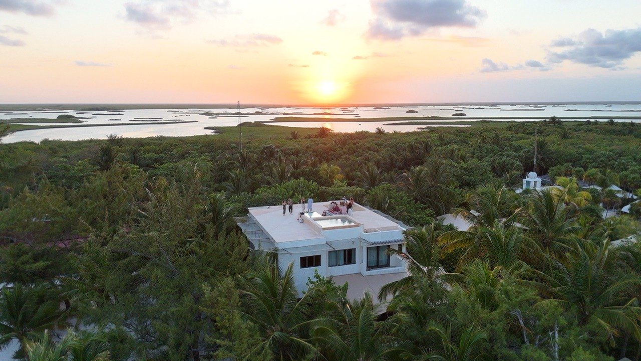 The villa among the jungle at sunset, with the lagoon behind