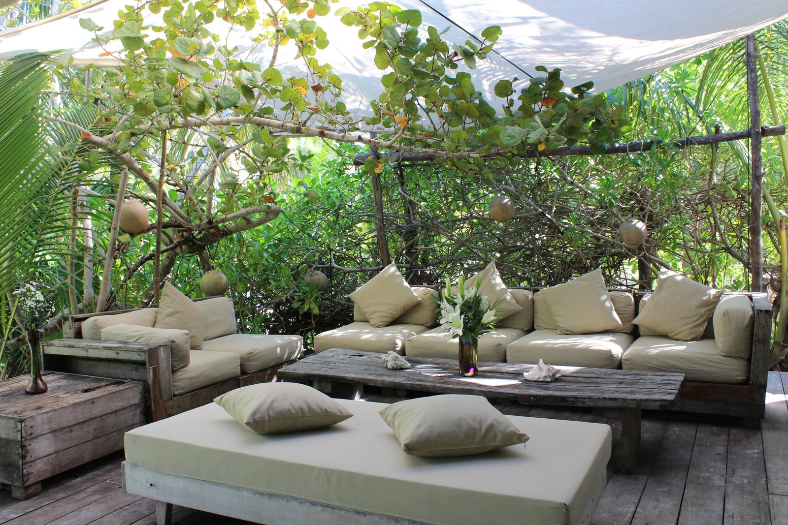 An outdoor lounge with sofas under the trees