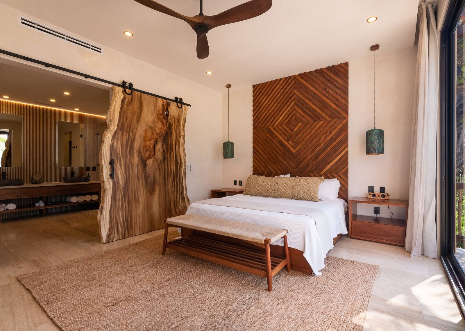 A suite with a carved wooden wall behind the bed